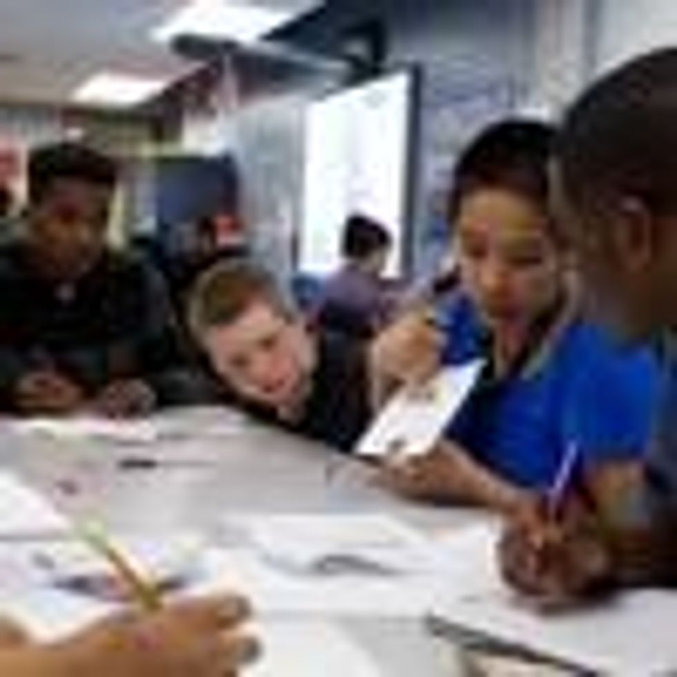 A teacher works with high school students