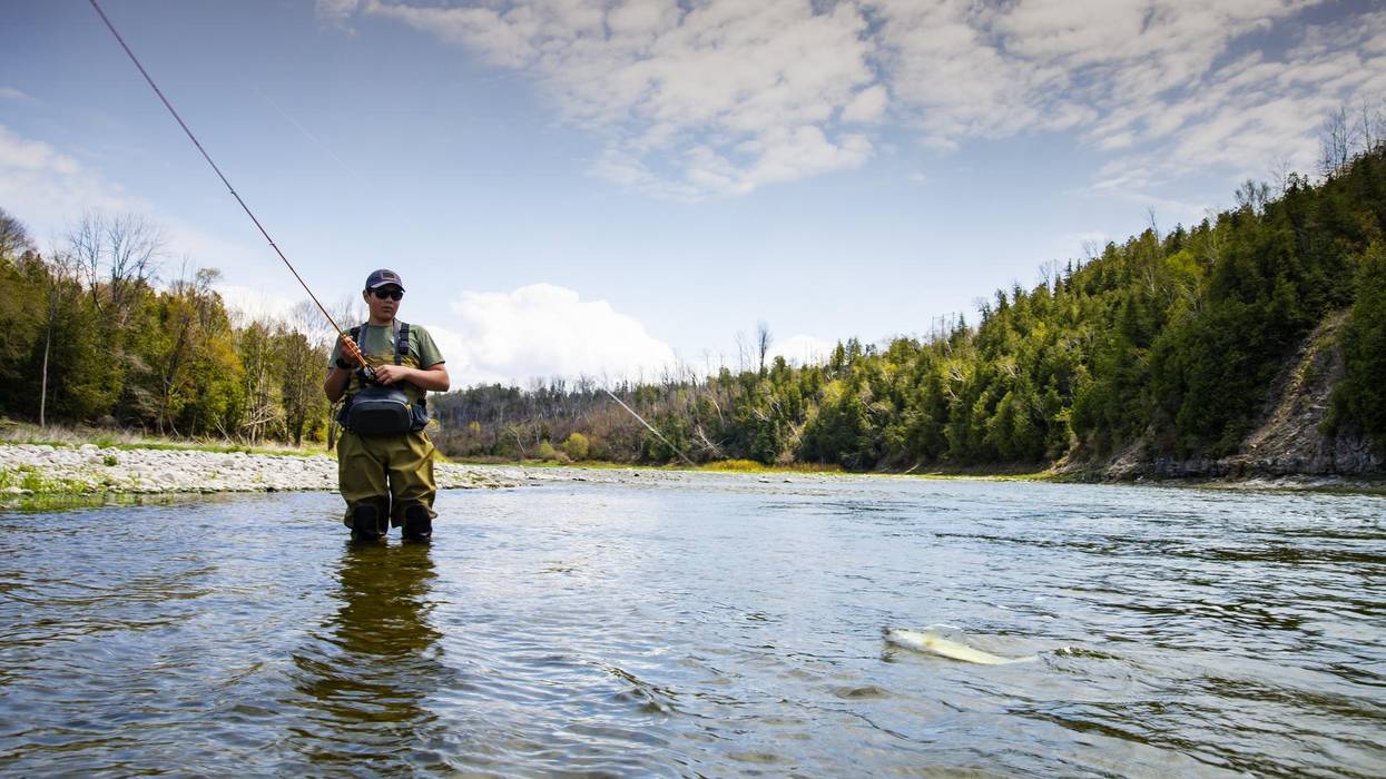 A teen fishes in a tributary river