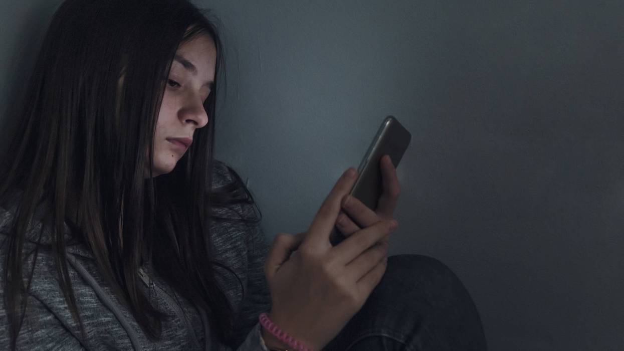 A teen girl looks at her cellphone