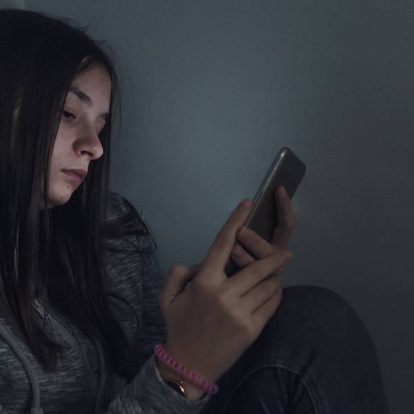 A teen girl looks at her cellphone