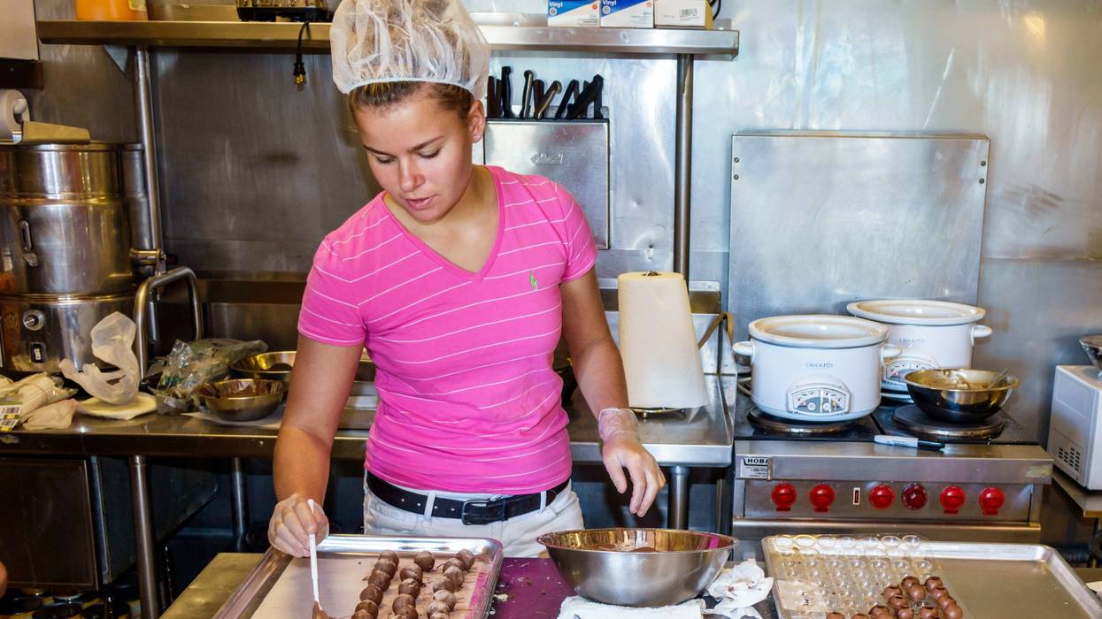 A teenager works in a chocolate shop
