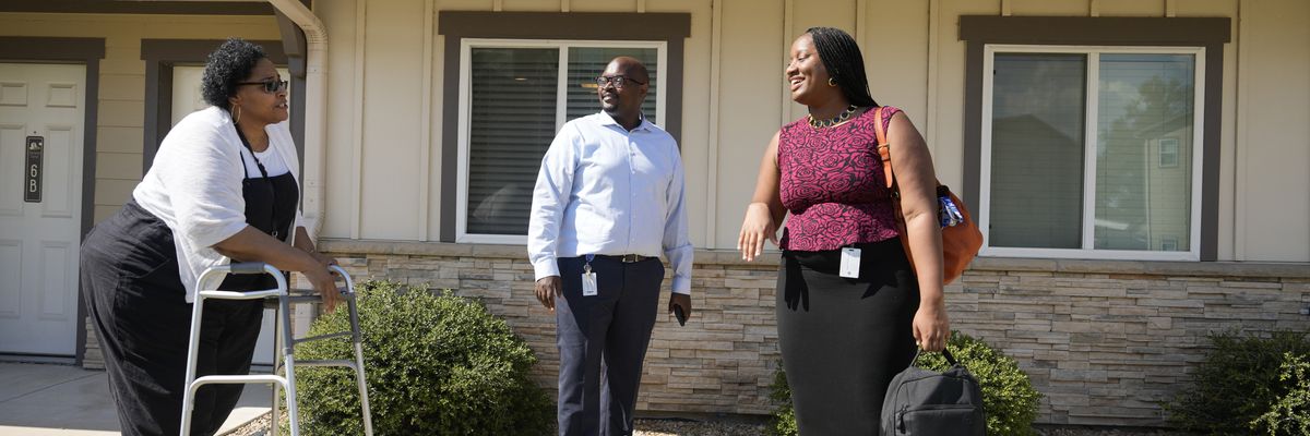 A tenant visits with government housing workers.
