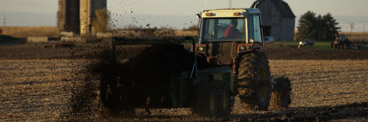 A tractor spreads sewage sludge-based fertilizer in a field