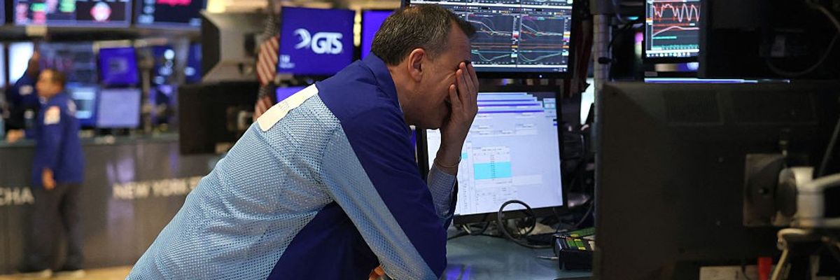 A trader face-palms at the New York Stock Exchange.