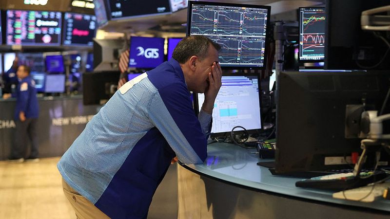 A trader face-palms at the New York Stock Exchange.
