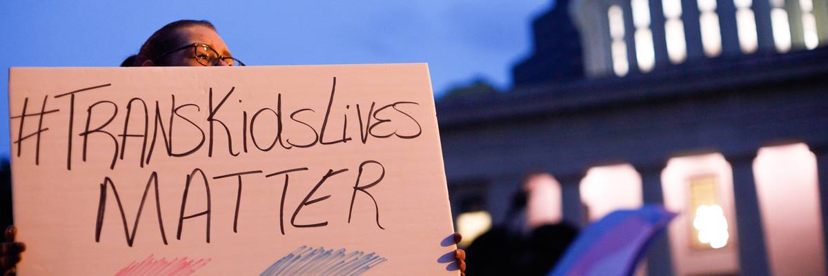 A transgender rights advocate holds a sign