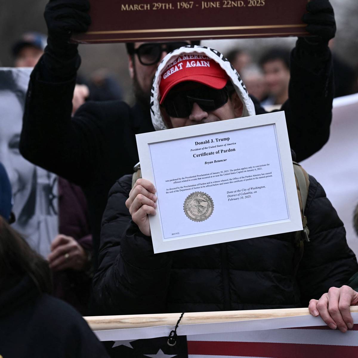 A Trump supporter holds up a certificate of pardon in connection with the January 6, 2021 Capitol insurrection