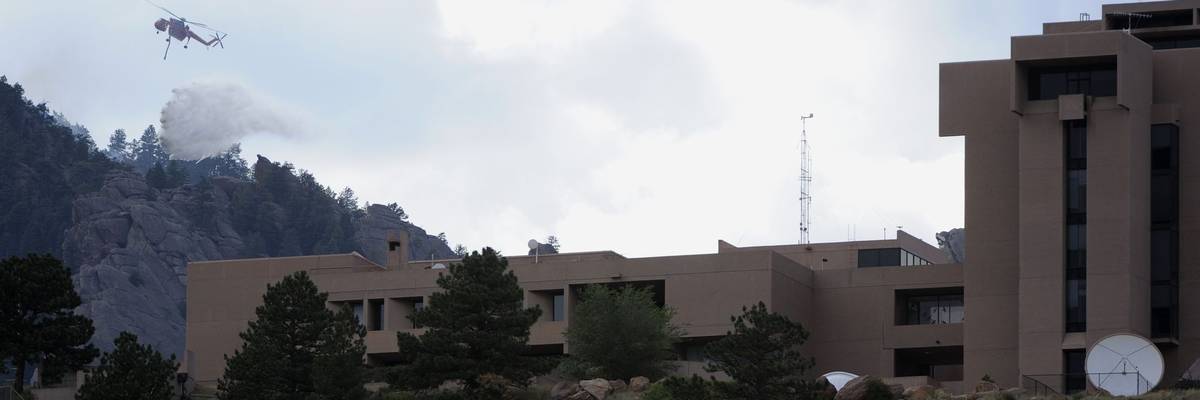 A type-1 helicopter makes a water drop on a lightning-caused spot fire high up in the Flatirons Thursday afternoon, June 28th, 2012. The spot fire was north of the Flagstaff Fire behind the National Center for Atmospheric Research, the NCAR building in Bo
