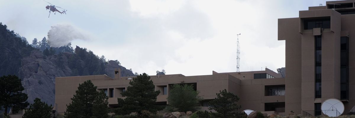 A type-1 helicopter makes a water drop on a lightning-caused spot fire high up in the Flatirons Thursday afternoon, June 28th, 2012. The spot fire was north of the Flagstaff Fire behind the National Center for Atmospheric Research, the NCAR building in Bo