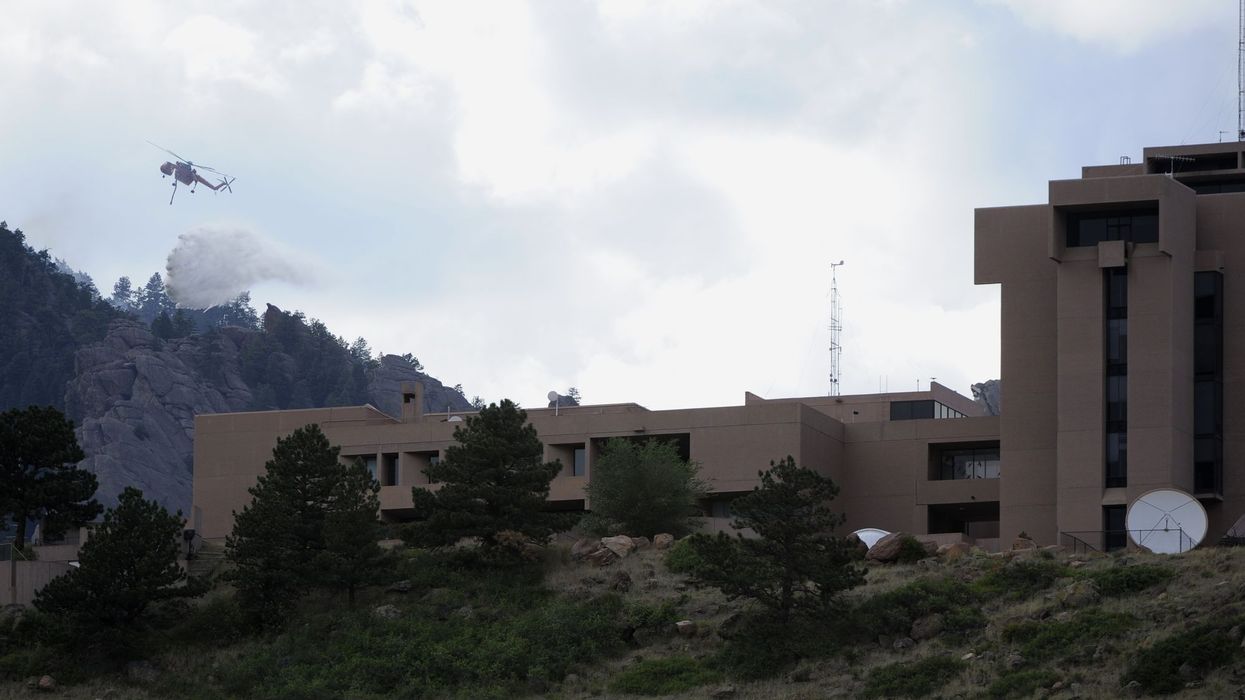 A type-1 helicopter makes a water drop on a lightning-caused spot fire high up in the Flatirons Thursday afternoon, June 28th, 2012. The spot fire was north of the Flagstaff Fire behind the National Center for Atmospheric Research, the NCAR building in Bo