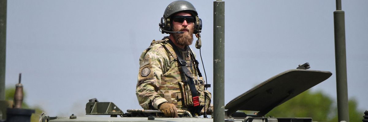 A U.S. army soldier stands in the hatch of a high mobility artillery rocket system launcher vehicle