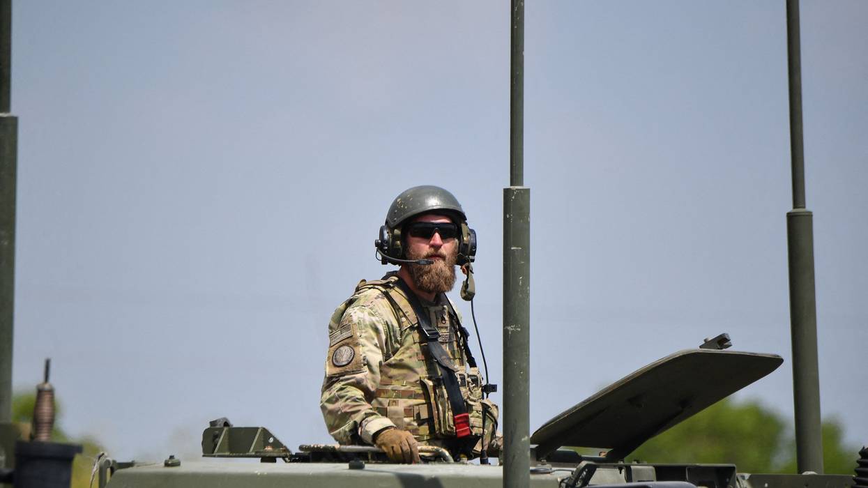 A U.S. army soldier stands in the hatch of a high mobility artillery rocket system launcher vehicle