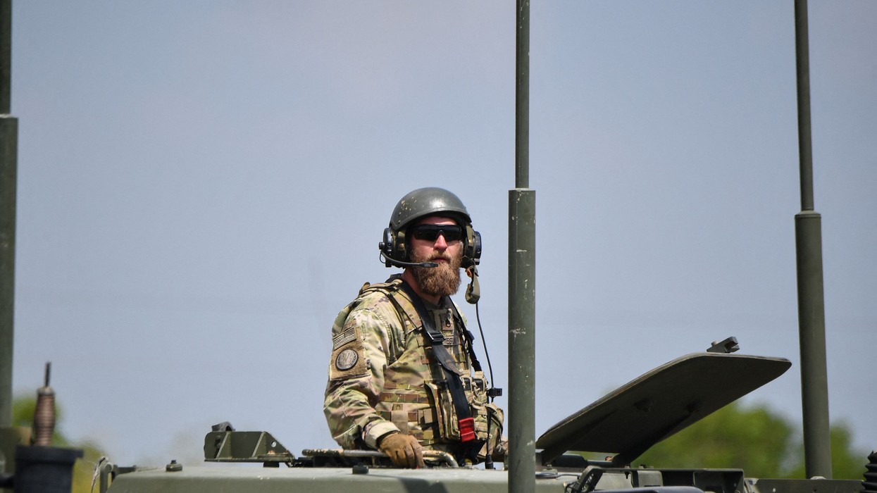 A U.S. army soldier stands in the hatch of a high mobility artillery rocket system launcher vehicle