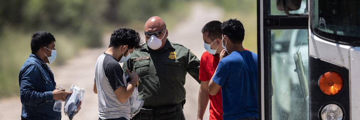 A U.S. Border Patrol agent instructs unaccompanied teenagers