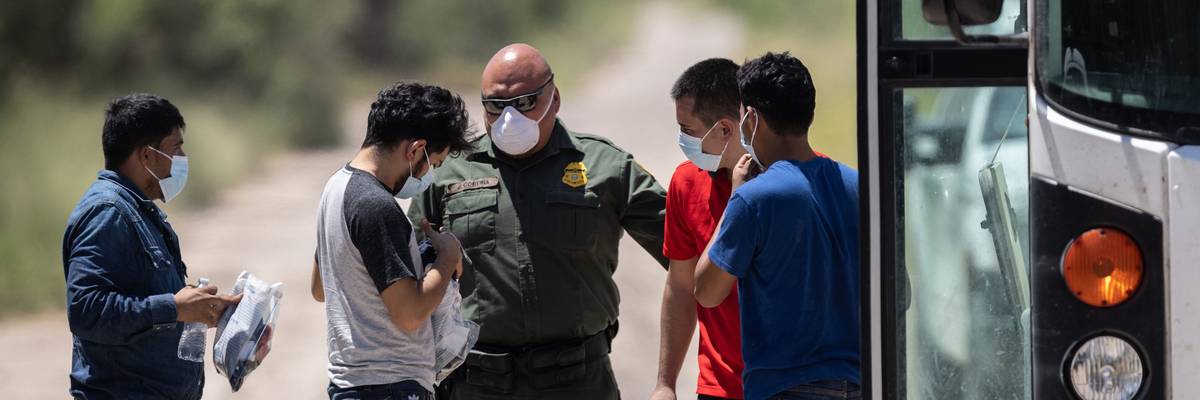 A U.S. Border Patrol agent instructs unaccompanied teenagers
