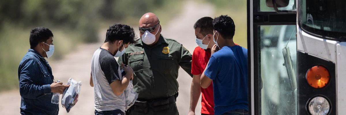 A U.S. Border Patrol agent instructs unaccompanied teenagers