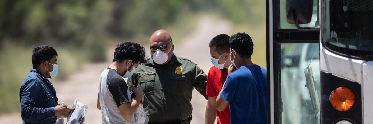 A U.S. Border Patrol agent instructs unaccompanied teenagers