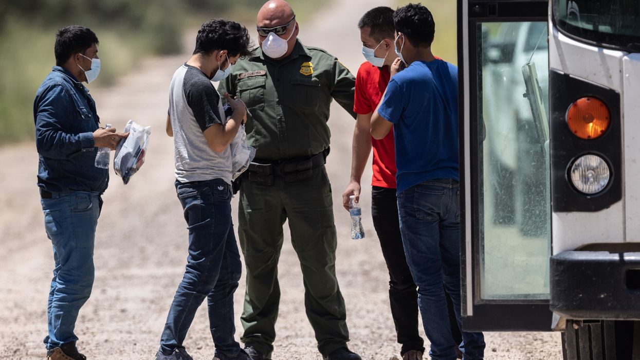 A U.S. Border Patrol agent instructs unaccompanied teenagers