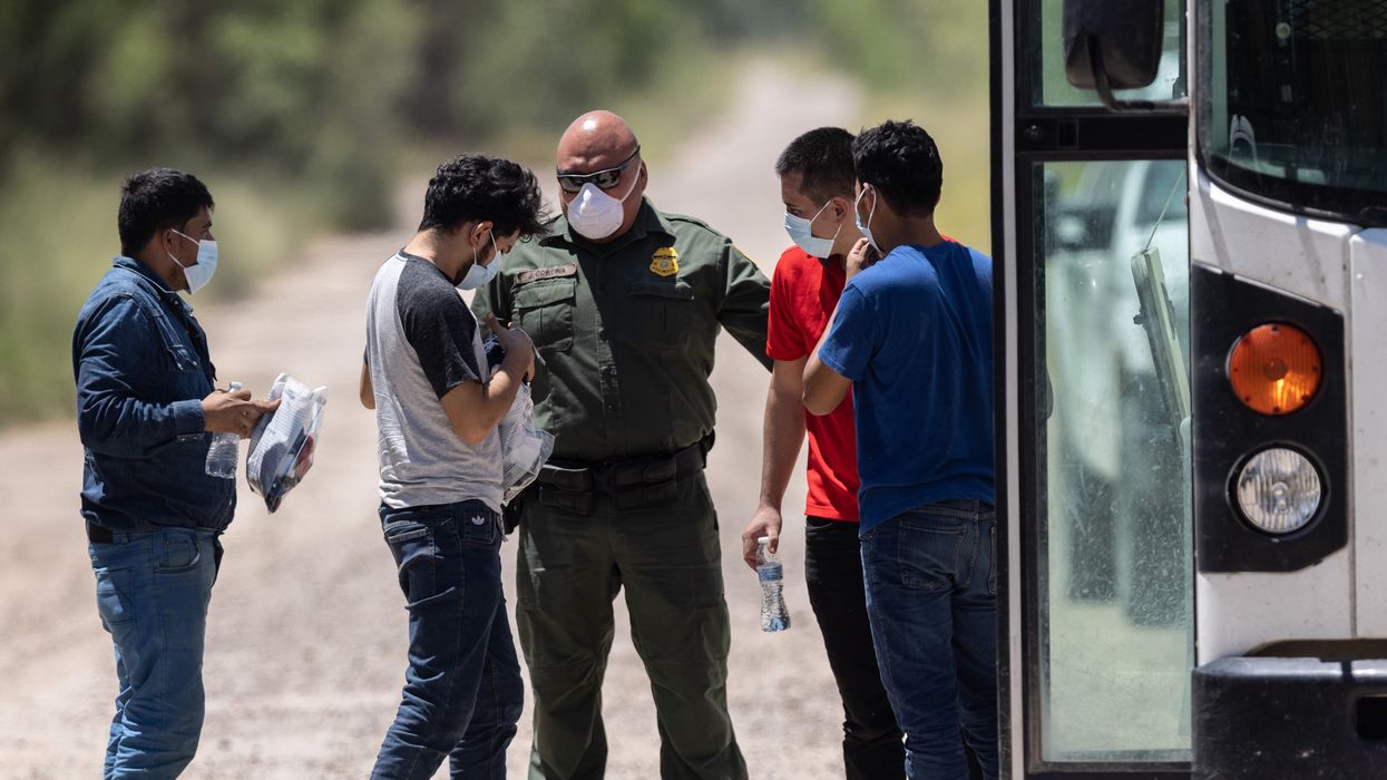 A U.S. Border Patrol agent instructs unaccompanied teenagers