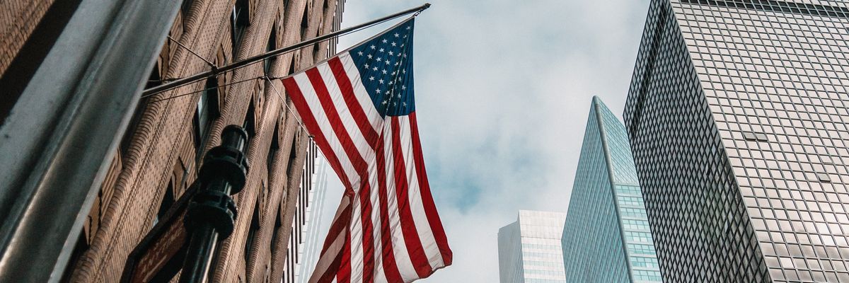 A U.S. flag flies between skyscrapers. 
