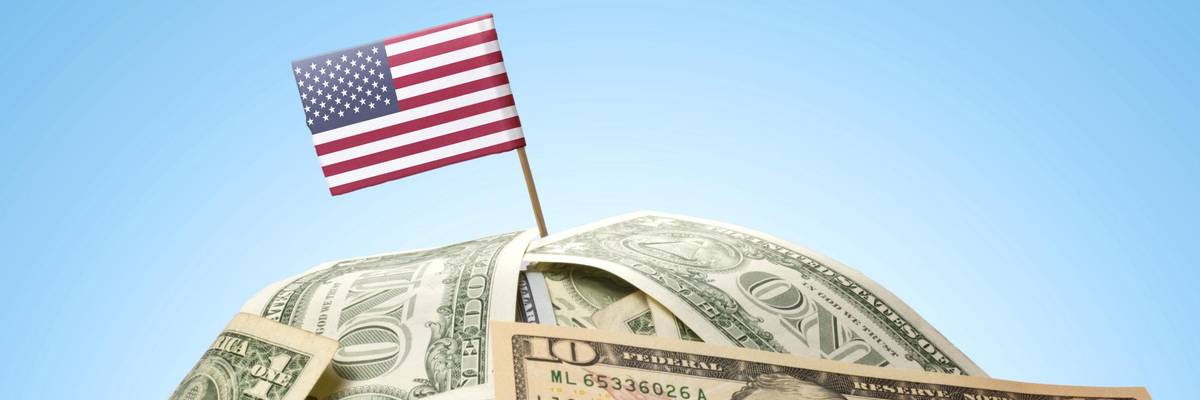 A U.S. flag is pictured on top of a pile of money.