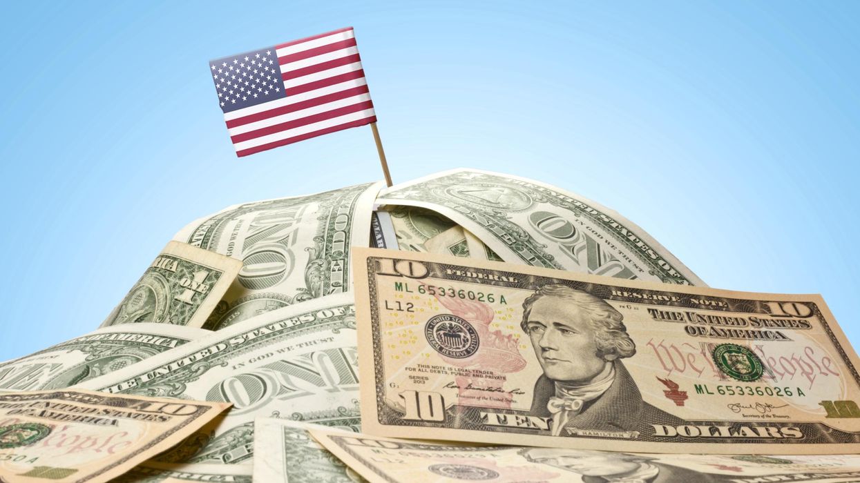 A U.S. flag is pictured on top of a pile of money.