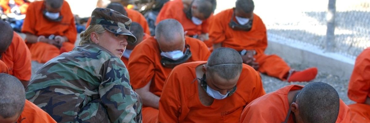 A U.S. servicewoman gives GITMO detainees water