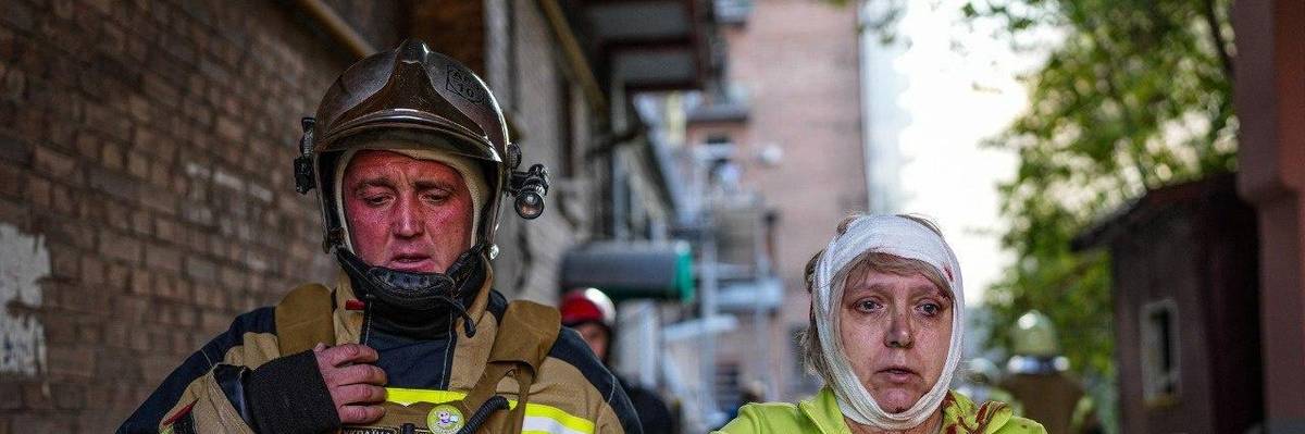A Ukrainian emergency worker assist a woman injured by Russian airstrikes