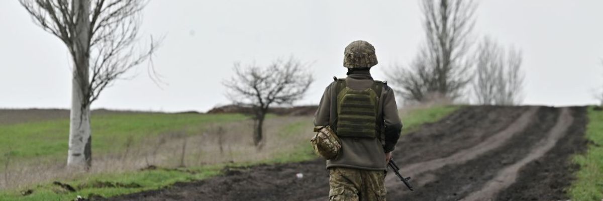 A Ukrainian serviceman walks along a road
