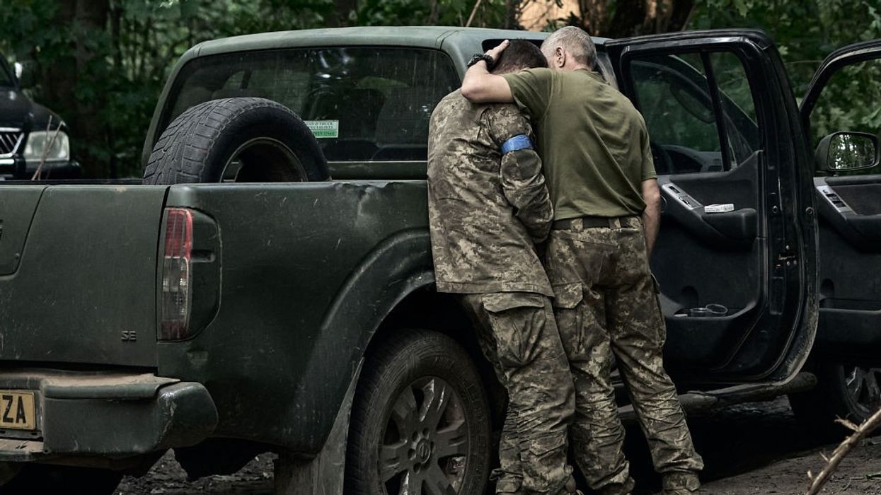 A Ukrainian soldier cries on his comrade's shoulder
