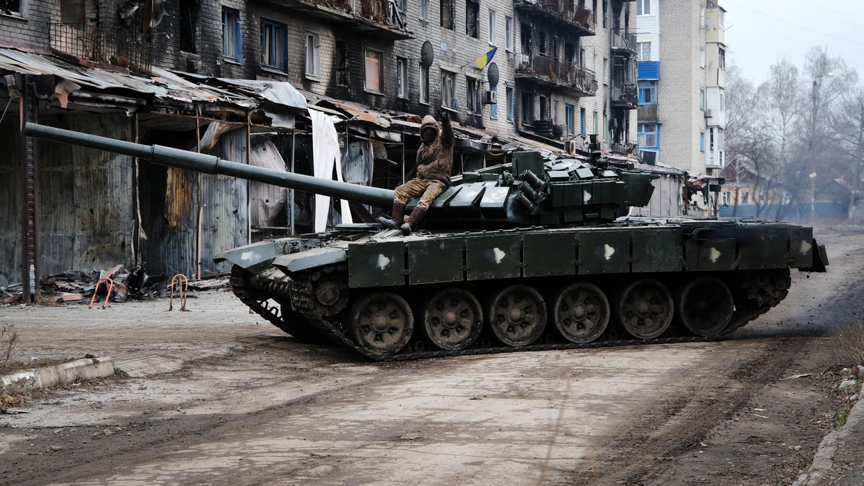 A Ukrainian tank drives down a street in the heavily damaged town of Siversk
