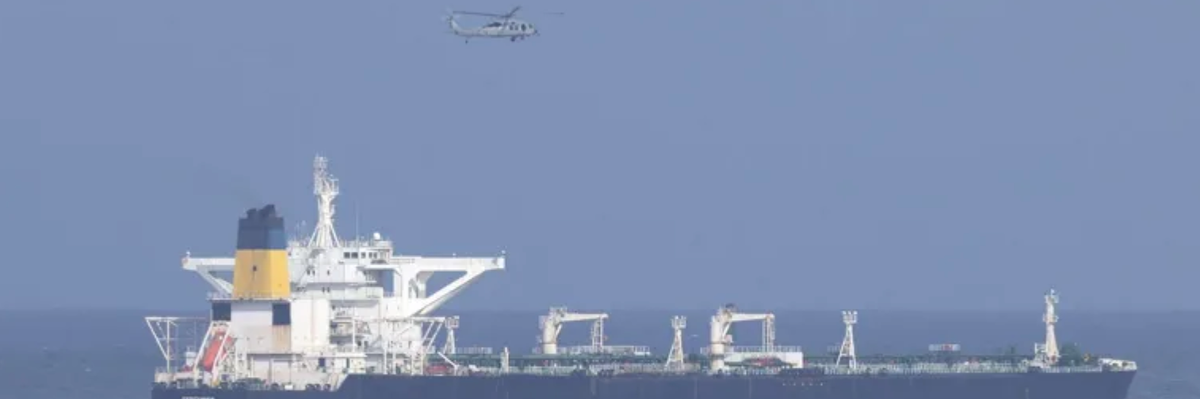 A US helicopter flies over an oil tanker at sea