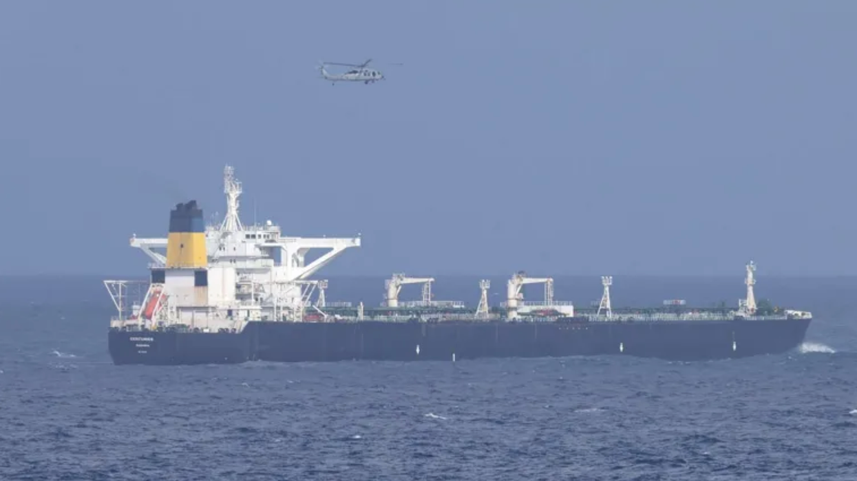 A US helicopter flies over an oil tanker at sea