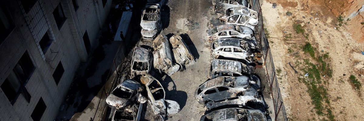A view over the village of Hawara, including a line of burned vehicles, after settlers riot and set houses and cars on fire in the village of Hawara