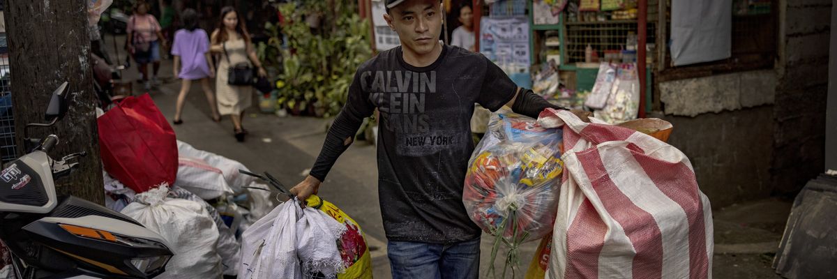 A village worker scavenges recyclable materials
