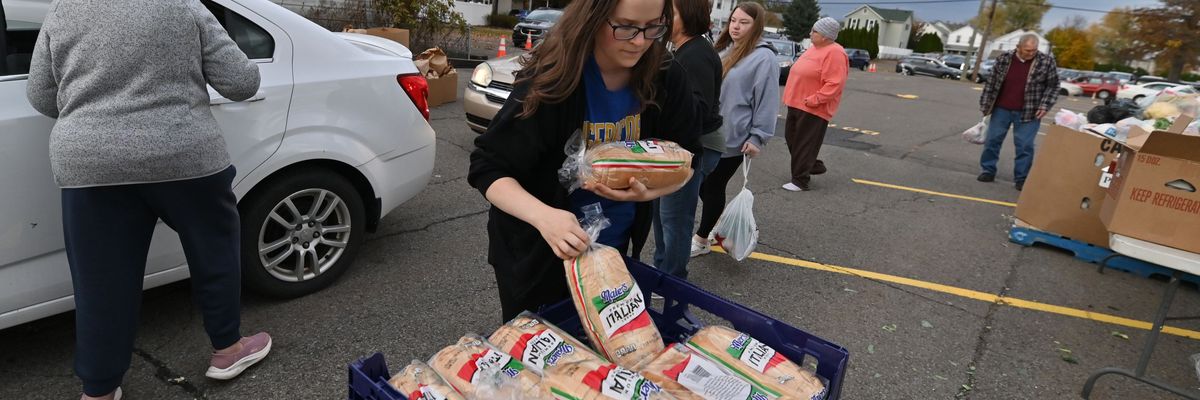 A volunteer grabs bread to hand out at a food distribution site in Kingston, Pennsylvania