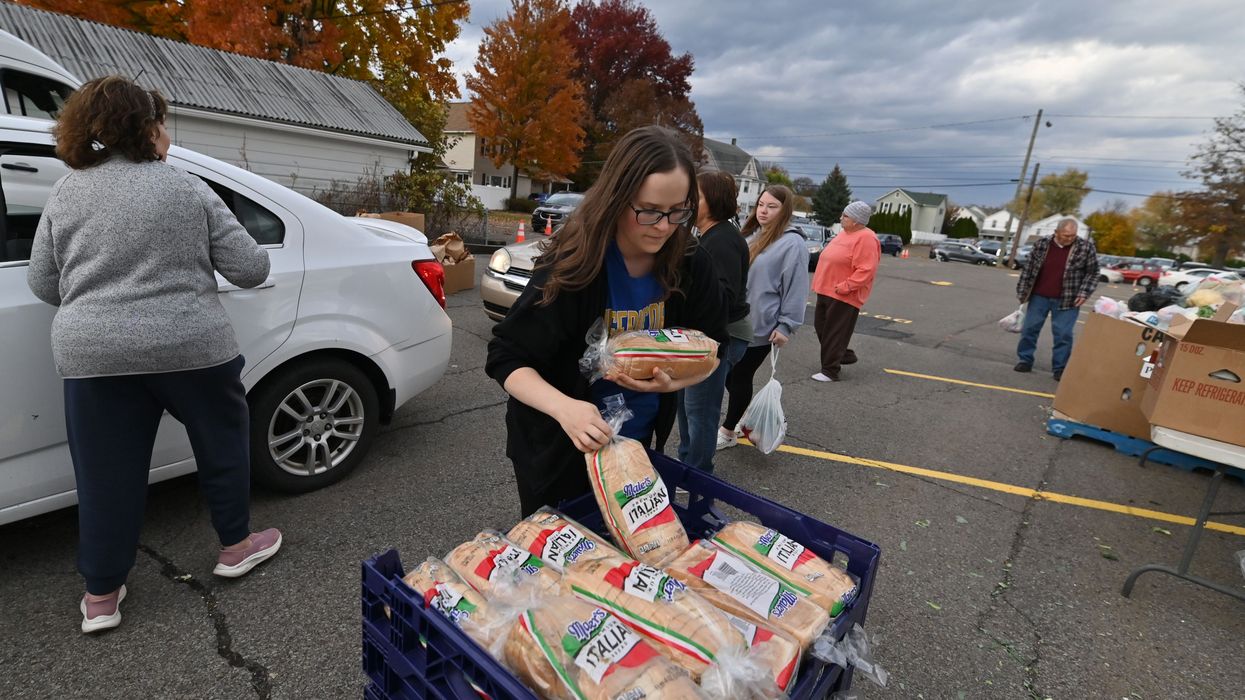 A volunteer grabs bread to hand out at a food distribution site in Kingston, Pennsylvania