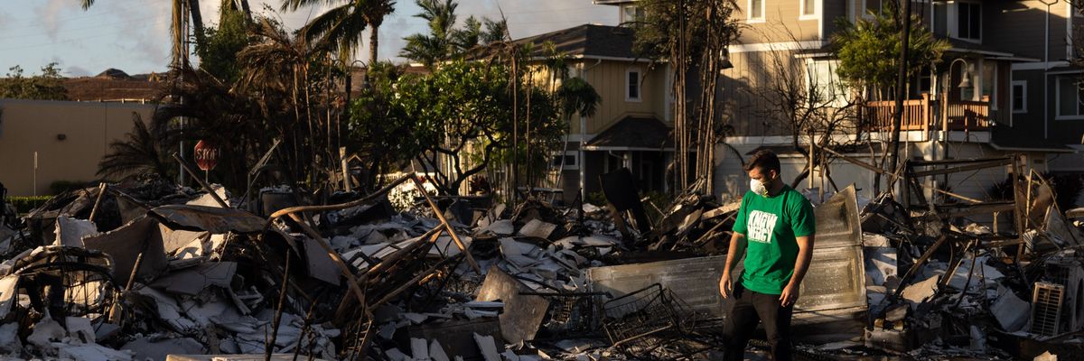 A volunteer makes a damage assessment of a charred apartment complex