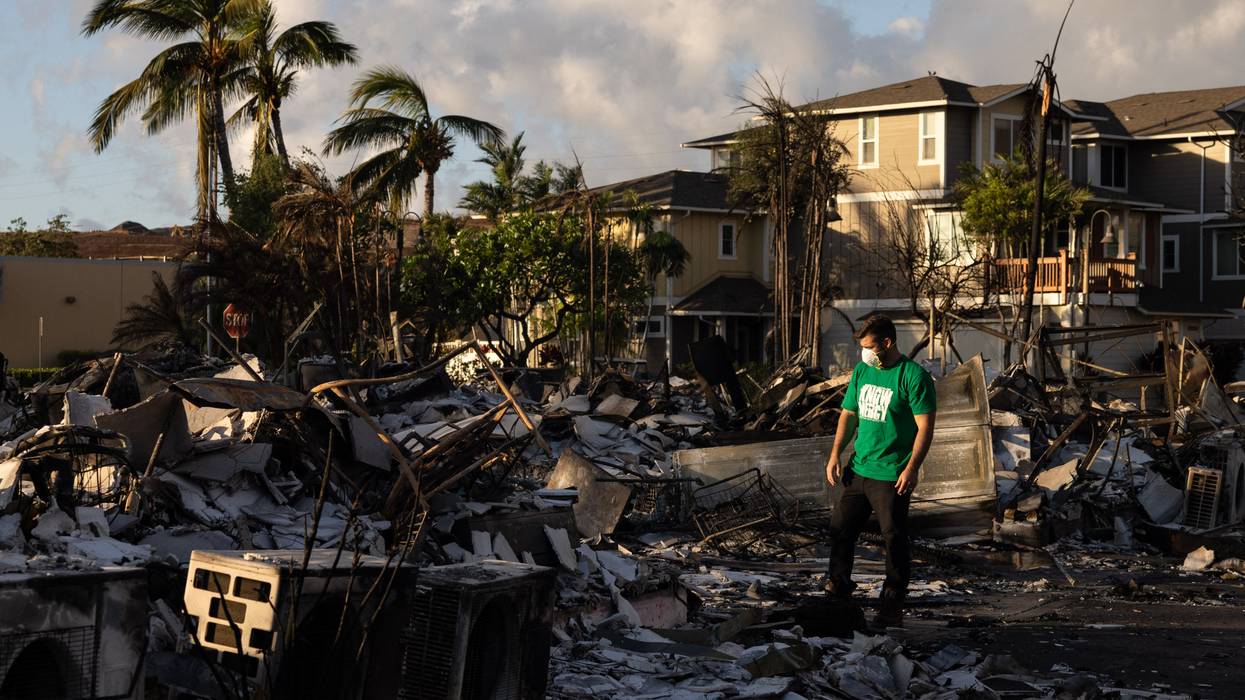 A volunteer makes a damage assessment of a charred apartment complex