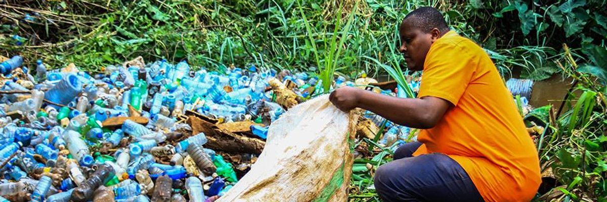 A volunteer removes plastic bottles and other trash polluting Ruaka River in Nairobi, Kenya.