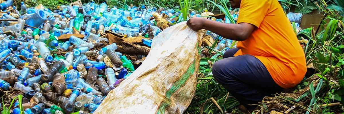 A volunteer removes plastic bottles and other trash polluting Ruaka River in Nairobi, Kenya