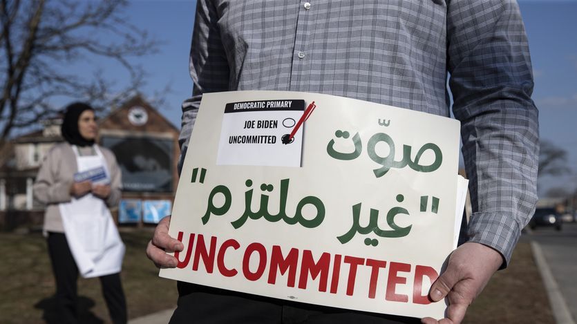 A volunteer with the Listen to Michigan campaign holds a sign reading, "Uncommitted"