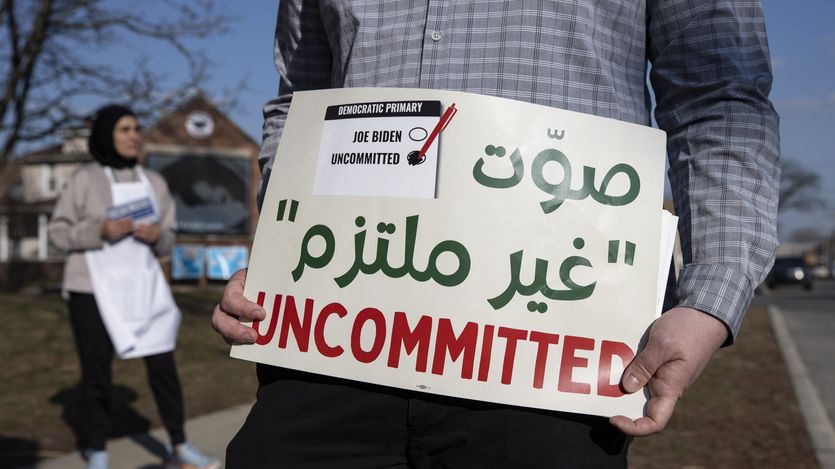 A volunteer with the Listen to Michigan campaign holds a sign reading, "Uncommitted"