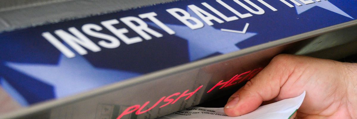 A voter uses a ballot drop box at the Bucks County Administration building