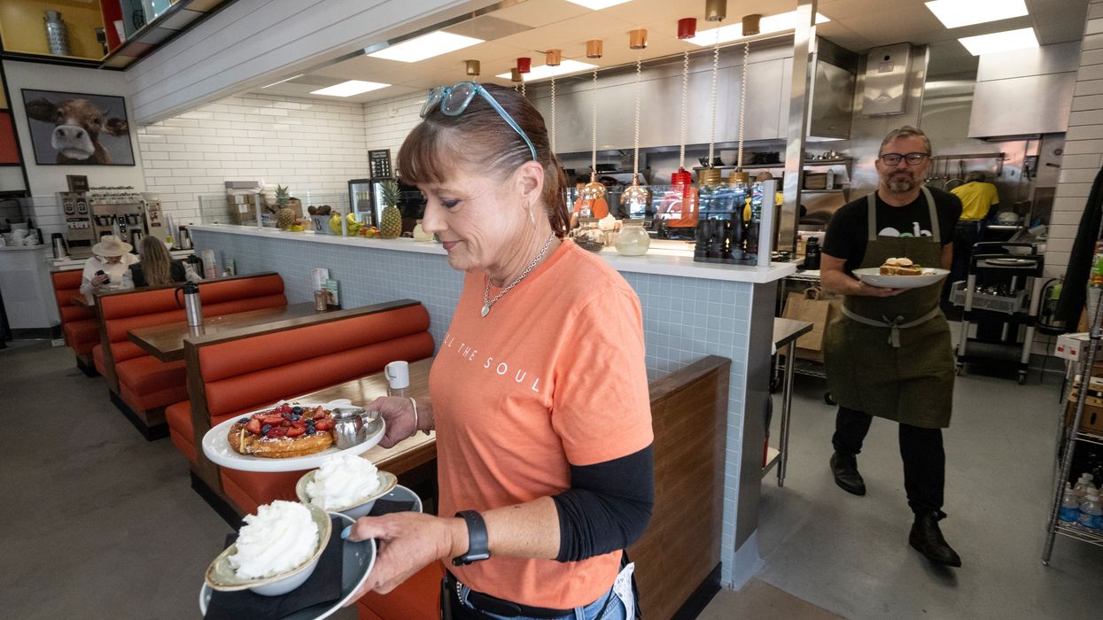 A waitress serves a meal at OEB Breakfast Co.