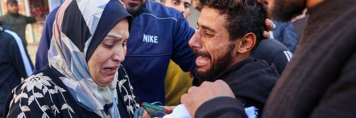 A woman and man cry looking at the body of dead child in Gaza
