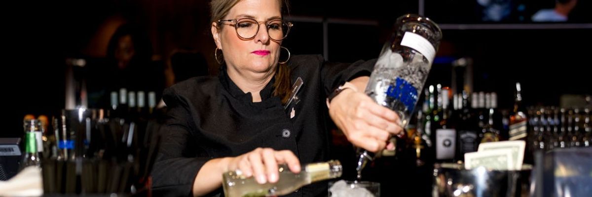 a woman bartender mixes a cocktail