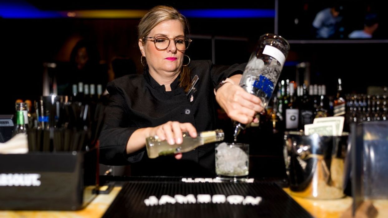 a woman bartender mixes a cocktail