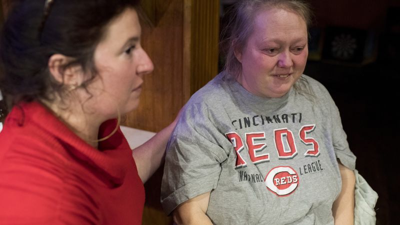 A woman comforts another over returning cancer.