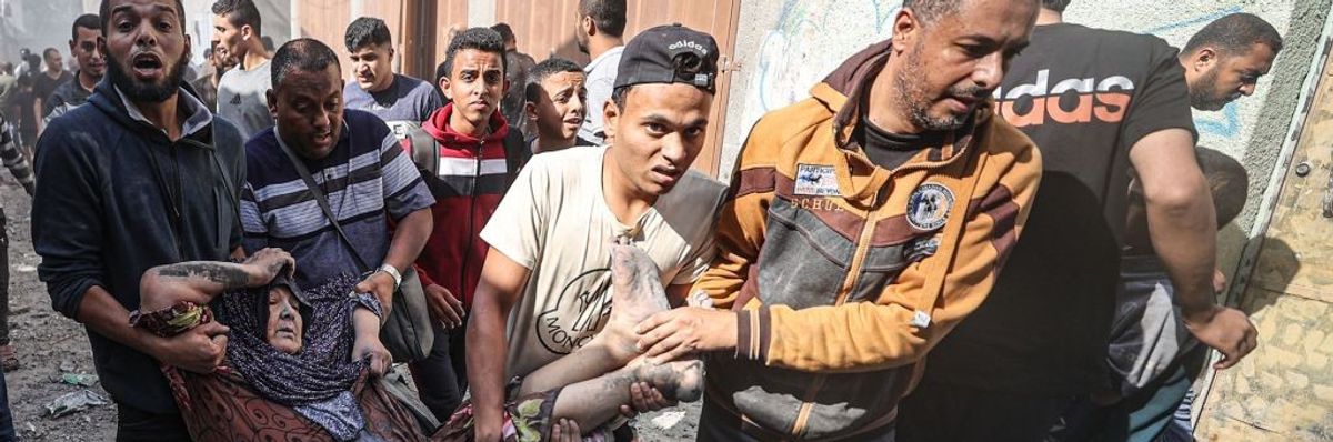 A woman covered in blood and dust being taken to a hospital by men in Gaza